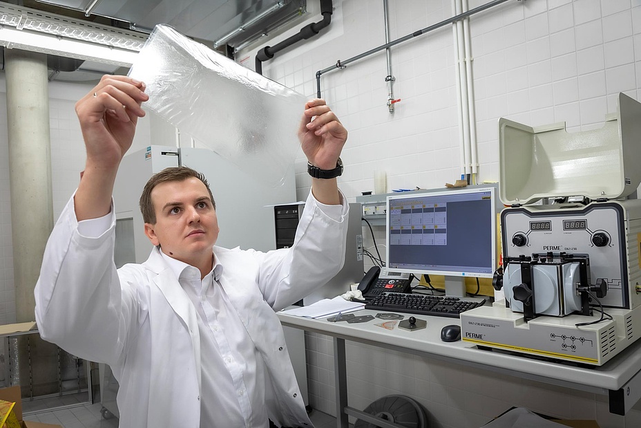 Forscher untersucht Kunststofffolie in Labor