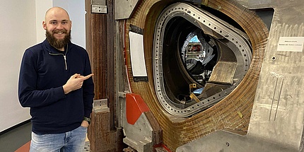 A young man points to a fusion reactor