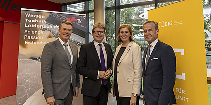 Four people, three men and one woman, smile into the camera.