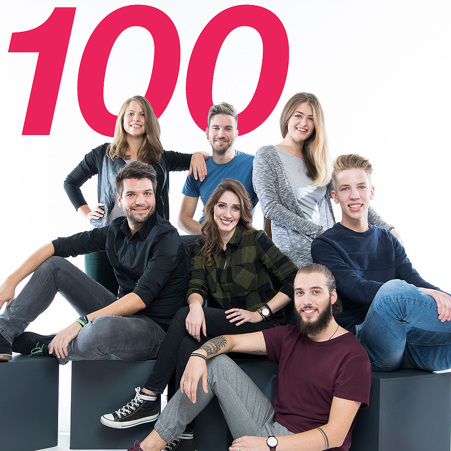 Junge Menschen des Studienschwerpunktes Information Security der TU Graz sitzen zusammen, Zahl 100 im Hintergrund