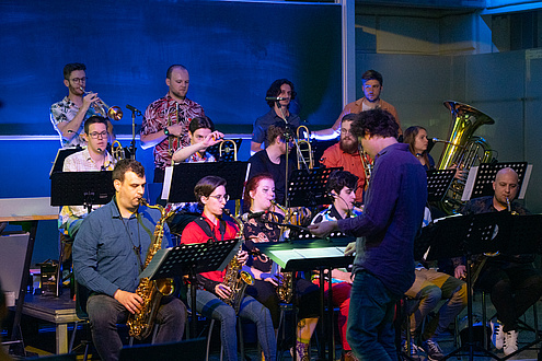 Mehrere Personen mit Instrumenten auf einer Bühne.