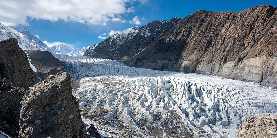 Die Eismasse eines Gletschers liegt zwischen zwei Bergketten.