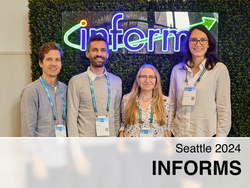 The four participants in front of the INFORMS logo.