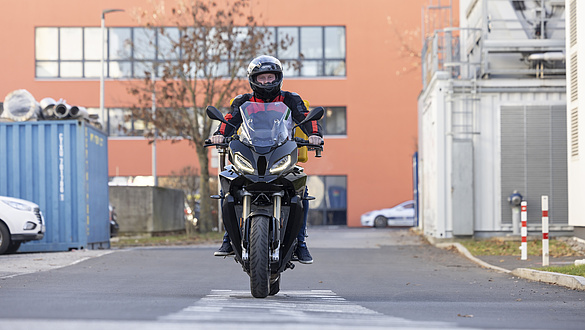 A man rides a motorbike towards the camera.