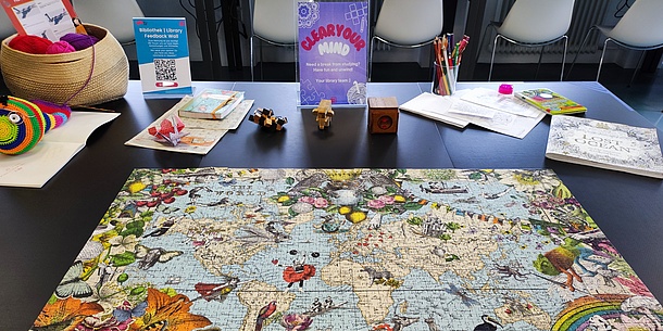 Table with puzzles, mandalas, crosswords and wool for crocheting