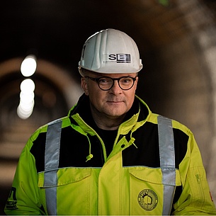 Robert Galler mit weißem Helm und neongelber Jacke in einem Tunnel