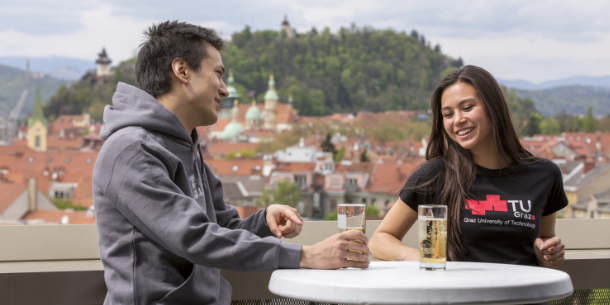 Two students on a terrace overlooking Graz