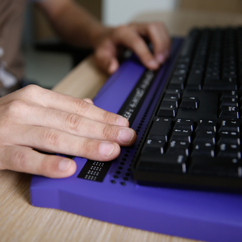 Person benutzt eine Braille-Tastatur